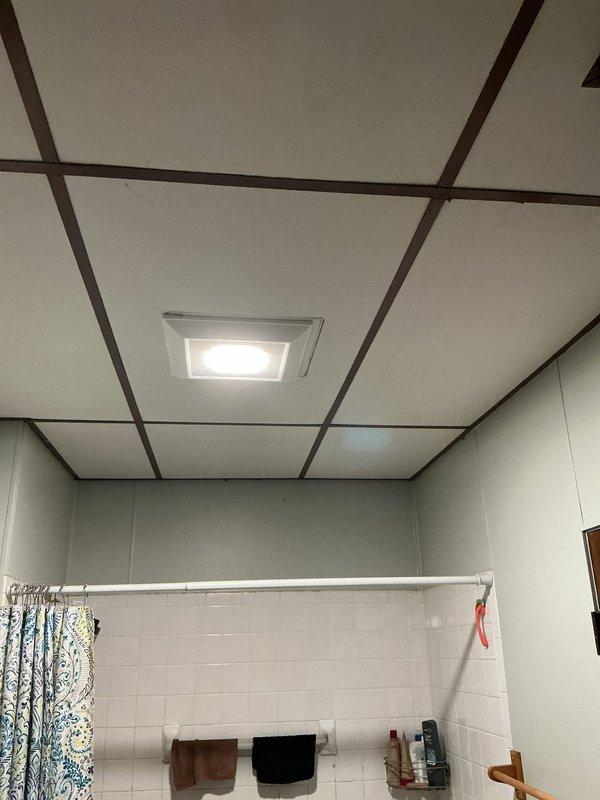 Responded to service call for bathroom light replacement. Removed existing recessed lighting fixture from drop ceiling grid system and installed new recessed LED light panel in ceiling tile opening. Verified proper electrical connections and tested fixture operation to ensure adequate illumination. Work completed as quoted.