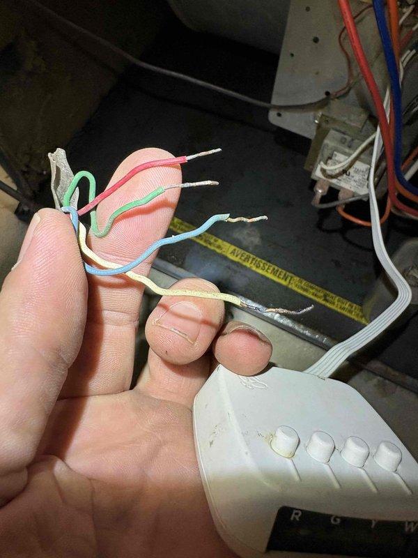 # CP-Cooling Problem Resolution

Responded to service call for 38-year-old Carrier system with no air circulation and inoperative blower fan following previous day's repair work. Upon arrival, diagnosed issue as improper thermostat wiring connection at control interface. Inspected thermostat terminal block and identified multiple loose or incorrectly landed wires on R, G, Y, and W terminals. Removed existing wire connections, verified wire integrity, stripped and prepared wire ends as needed, and properly reconnected all low-voltage control wiring according to manufacturer specifications. Confirmed proper seating of green (fan), red/pink (power), blue (common), tan (heat), and white (cooling) conductors. Restored power to system, tested thermostat functionality across all modes, and verified blower motor operation and proper air circulation throughout system. Unit now operating as designed with all functions restored.