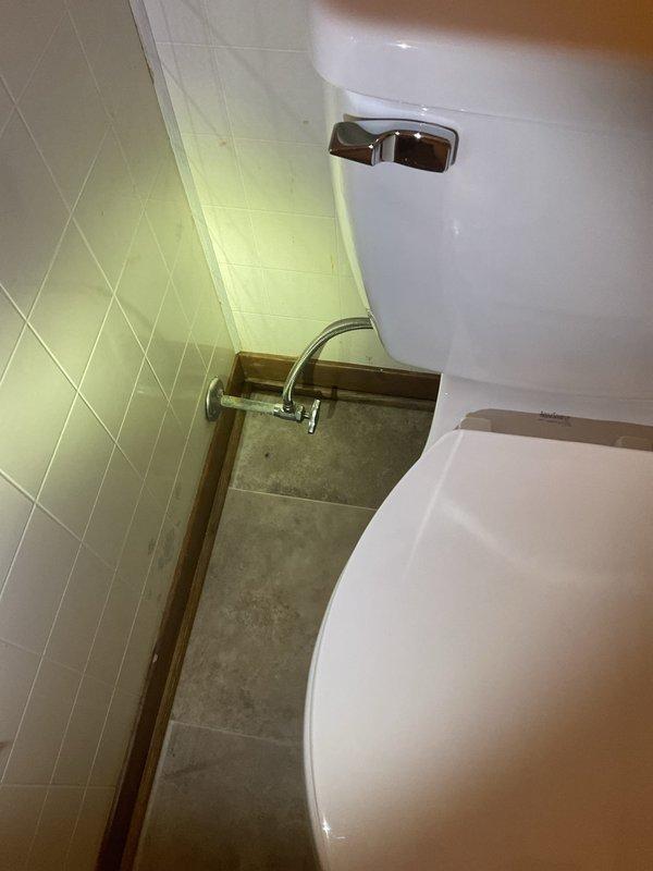 Conducted comprehensive plumbing assessment for toilet repair requirements in residential bathroom. Documented existing conditions including toilet fixture, water supply connections, cabinet accessibility, and structural elements in ceiling area above, identifying necessary scope of work for complete toilet repair and potential rough plumbing modifications.