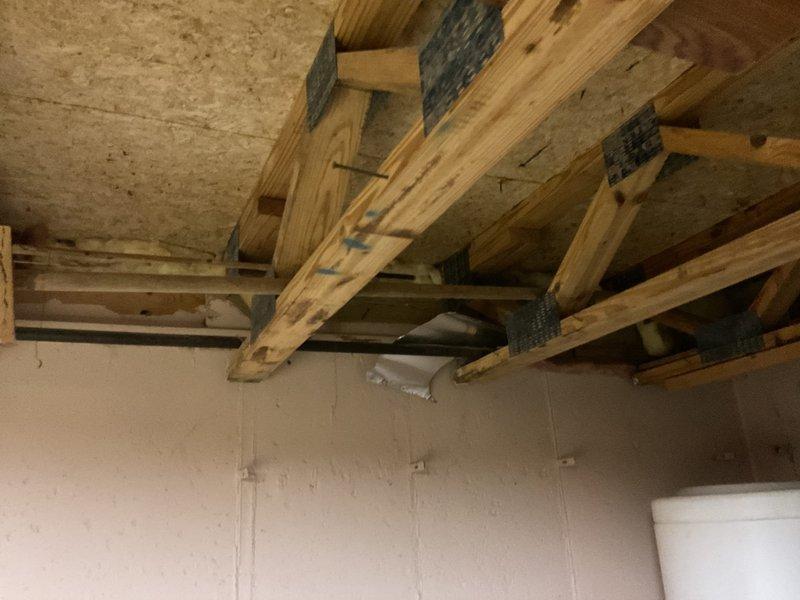 Conducted comprehensive plumbing assessment for toilet repair requirements in residential bathroom. Documented existing conditions including toilet fixture, water supply connections, cabinet accessibility, and structural elements in ceiling area above, identifying necessary scope of work for complete toilet repair and potential rough plumbing modifications.