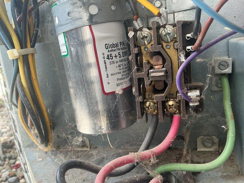 Completed annual cooling maintenance on 29-year-old Bryant air conditioning system. Performed comprehensive system inspection including electrical components, capacitor testing, and condensate drain evaluation. Verified proper operation of contactor assembly and confirmed 45+5 MFD dual capacitor specifications within acceptable parameters. Inspected all wire connections for tightness and proper termination. Assessed condensate drainage system and PVC piping for proper function and clearance. Documented equipment condition with photos showing capacitor assembly, electrical connections, and auxiliary equipment location. Confirmed updated contact information for service records. System operating normally at time of departure.