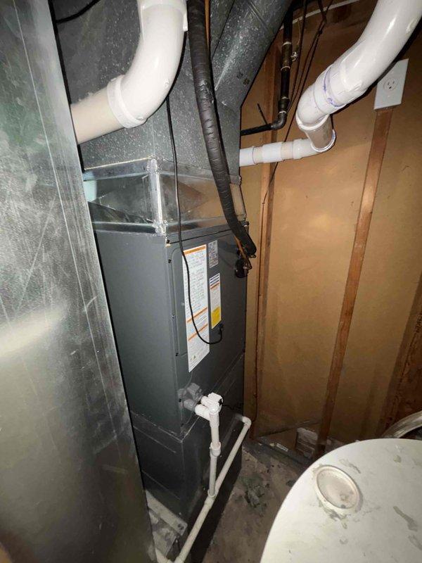 Completed full HVAC system replacement including installation of new air handler unit in basement utility area and outdoor condensing unit. Air handler was mounted vertically against interior wall framing with proper PVC condensate drain lines and ventilation piping installed. Connected flexible ductwork and metallic supply/return ductwork to new air handler. Outdoor condenser unit was positioned on concrete pad in side yard with appropriate clearance for airflow and service access. Refrigerant lines were properly routed and secured along exterior wall connecting indoor and outdoor components. All electrical connections completed per manufacturer specifications. System was pressure tested, evacuated, charged with refrigerant, and commissioned. Verified proper operation of all components including airflow, temperature differential, and drainage system functionality.