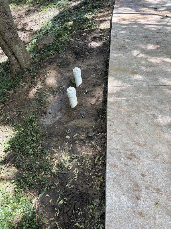 Completed installation of new cleanout access point in existing sewer line system. Excavated trench to expose underground piping, installed white PVC cleanout assembly with gray elbow fittings to provide maintenance access, and performed high-pressure water jetting of the line to clear blockages and restore proper flow. Backfilled and restored work area upon completion.