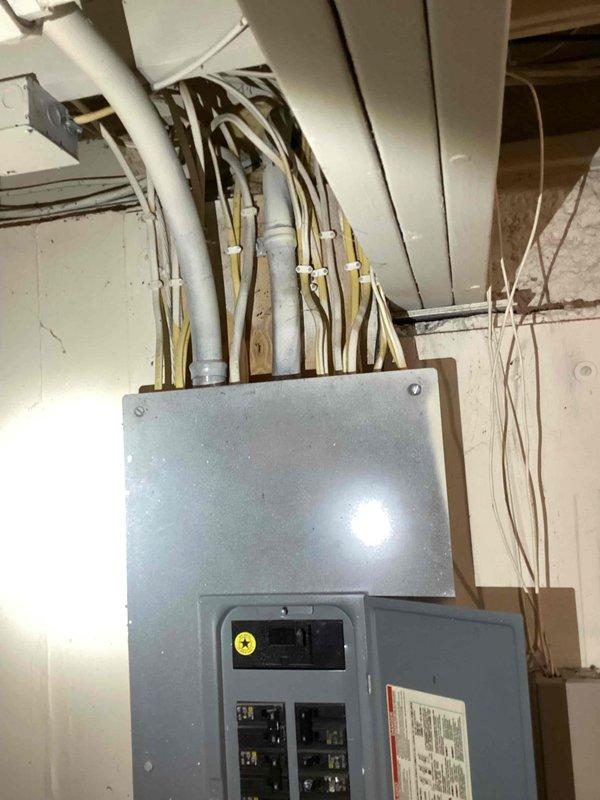 Provided estimate for replacement of 28-year-old 1998 Lennox 5-ton packaged cooling-only unit utilizing R-22 refrigerant, which was deemed non-repairable by previous technician. Documented existing electrical panel and breaker configuration in basement utility area to assess compatibility with replacement equipment. Unit connects through exterior wall to existing ductwork; home utilizes separate boiler and baseboard heating system that will remain unchanged.