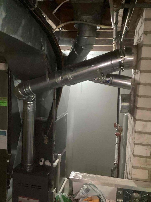 Responded to inspector correction for improperly sized chimney liner installation. Removed existing 4-inch liner and installed new 5-inch chimney liner to accommodate both water heater and furnace venting requirements per code. Replaced defective gas shut-off valve and coupler on water heater to ensure proper safety compliance. All venting connections secured and tested for proper draft and combustion safety.