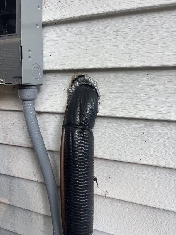 Completed annual cooling system tune-up and inspection. Documented deteriorated insulation on refrigerant line set requiring attention, with foam insulation showing significant weathering and separation at exterior wall penetration. Inspected electrical control board and capacitor connections, verifying all wire terminations and component conditions within acceptable parameters.
