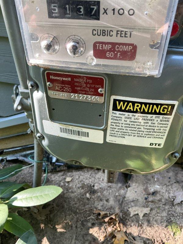 Conducted site assessment for whole house generator installation at 40-year-old residential property with no existing backup power system. Evaluated natural gas meter location and specifications, confirming DTE utility service with Honeywell meter rated at 6 PSI and temperature compensated to 60°F. Documented installation pathway and reviewed potential mounting location on exterior wall with vinyl siding. Assessed landscaping considerations including mature fern beds and broadleaf evergreens in proximity to proposed generator pad location. Verified adequate clearances from structure and vegetation for code-compliant installation. Photographed existing utility infrastructure and site conditions to develop comprehensive installation estimate.
