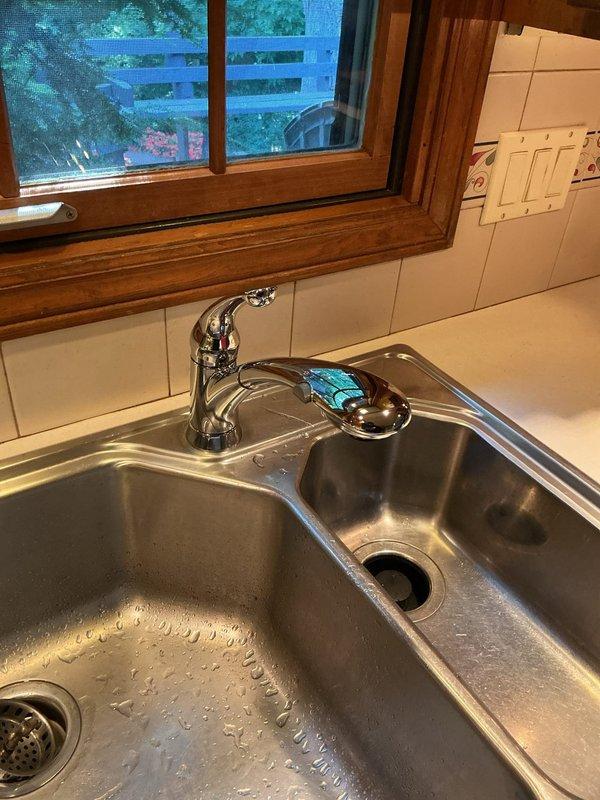 Completed installation of customer-supplied chrome single-handle faucet on stainless steel double-basin kitchen sink. Removed existing faucet, installed new unit with proper mounting and supply line connections, tested operation and verified no leaks. Installation completed within estimated timeframe with system functioning properly.