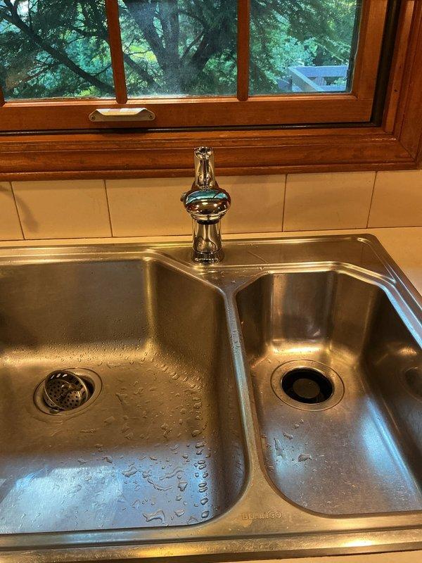 Completed installation of customer-supplied chrome single-handle faucet on stainless steel double-basin kitchen sink. Removed existing faucet, installed new unit with proper mounting and supply line connections, tested operation and verified no leaks. Installation completed within estimated timeframe with system functioning properly.