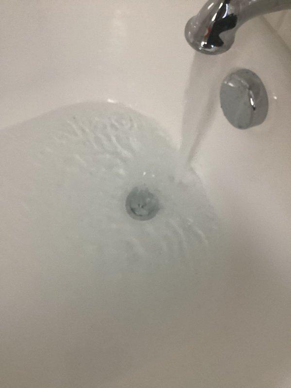 Responded to upstairs shower concerns regarding low water pressure and drainage issues. Inspected bathroom fixtures and plumbing components. Snaked bathtub drain to clear blockage and restore proper water flow. Assessed showerhead performance and water pressure at fixtures. Documented existing conditions of bathtub, drain assembly, and floor drain with chrome overflow plate and standard residential fixtures in working order.