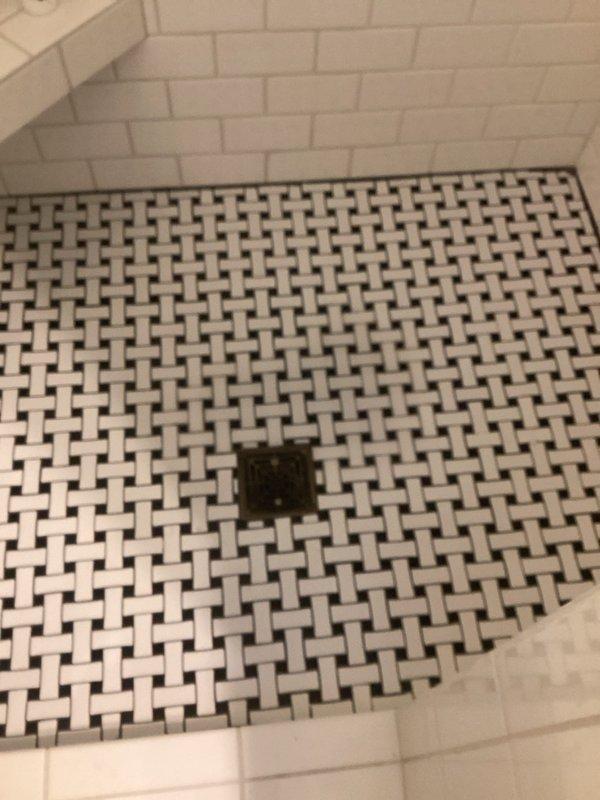 Responded to upstairs shower concerns regarding low water pressure and drainage issues. Inspected bathroom fixtures and plumbing components. Snaked bathtub drain to clear blockage and restore proper water flow. Assessed showerhead performance and water pressure at fixtures. Documented existing conditions of bathtub, drain assembly, and floor drain with chrome overflow plate and standard residential fixtures in working order.