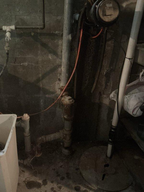 Responded to service call for non-operational sump pump in 68-year-old residential property. Upon arrival, conducted visual inspection of basement mechanical room and identified aging sump pump system with deteriorated components. Assessed plumbing infrastructure including PVC drainage lines, galvanized steel piping, and associated utility connections showing significant wear consistent with property age. Examined electrical connections including visible orange wiring and verified power supply to pump unit. Documented existing conditions of mechanical room including water heater, utility sink, concrete floor with moisture staining, and overall aging infrastructure. Inspected crawl space and attic areas to trace drainage routing and copper piping runs through structural joists. Photographed installation for service records. Identified pump failure likely due to age-related component deterioration in original mechanical system.