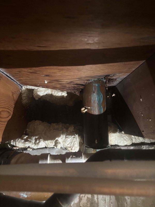 Responded to toilet leak in residential bathroom of 50-year-old home. Upon inspection, identified corroded copper supply line in crawl space beneath bathroom showing significant patina and deterioration. Applied absorbent material to bathroom floor to manage water infiltration and prevent further damage to surrounding areas. Documented existing plumbing conditions including aged copper piping and structural access points. Leak was successfully isolated to toilet supply connection, with damage contained to immediate bathroom area.