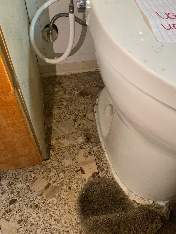 Responded to toilet leak in residential bathroom of 50-year-old home. Upon inspection, identified corroded copper supply line in crawl space beneath bathroom showing significant patina and deterioration. Applied absorbent material to bathroom floor to manage water infiltration and prevent further damage to surrounding areas. Documented existing plumbing conditions including aged copper piping and structural access points. Leak was successfully isolated to toilet supply connection, with damage contained to immediate bathroom area.