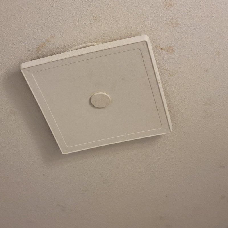 Responded to electrical service call for bathroom exhaust fan installation. Upon arrival, inspected existing ceiling-mounted ventilation system and found severely corroded mounting bracket and deteriorated hardware on the old fan unit. Removed damaged access panel and extracted old bathroom exhaust fan assembly, which exhibited extensive rust damage to metal components and compromised structural integrity. Installed customer-provided replacement bathroom exhaust fan, ensuring proper electrical connections, secure mounting, and adequate ventilation clearance. Tested unit operation to verify proper functionality and airflow. Replaced ceiling access panel and left work area clean.