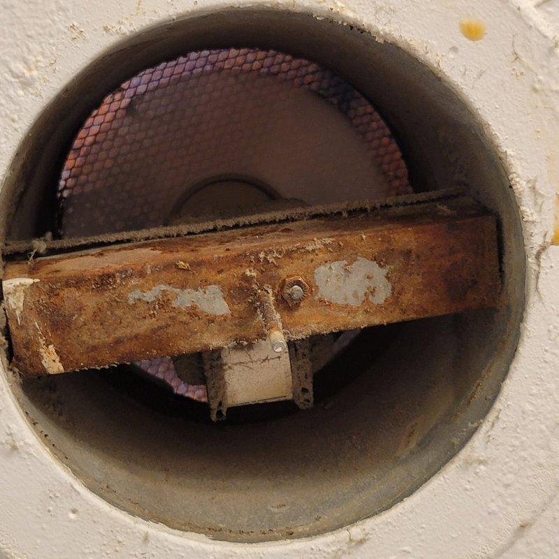 Responded to electrical service call for bathroom exhaust fan installation. Upon arrival, inspected existing ceiling-mounted ventilation system and found severely corroded mounting bracket and deteriorated hardware on the old fan unit. Removed damaged access panel and extracted old bathroom exhaust fan assembly, which exhibited extensive rust damage to metal components and compromised structural integrity. Installed customer-provided replacement bathroom exhaust fan, ensuring proper electrical connections, secure mounting, and adequate ventilation clearance. Tested unit operation to verify proper functionality and airflow. Replaced ceiling access panel and left work area clean.