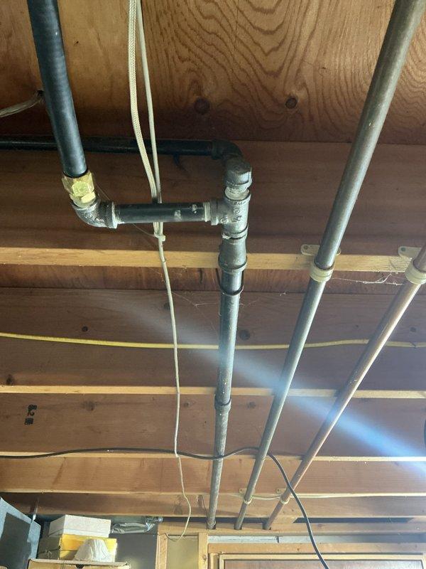 Responded to outdoor faucet spraying issue and capped off gas line as requested. Inspected exposed plumbing infrastructure in ceiling space, which included galvanized steel piping with threaded fittings and various utility lines, and completed necessary repairs to resolve the water spray problem.