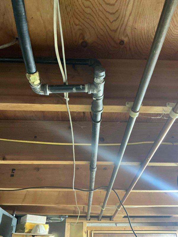Responded to outdoor faucet spraying issue and capped off gas line as requested. Inspected exposed plumbing infrastructure in ceiling space, which included galvanized steel piping with threaded fittings and various utility lines, and completed necessary repairs to resolve the water spray problem.