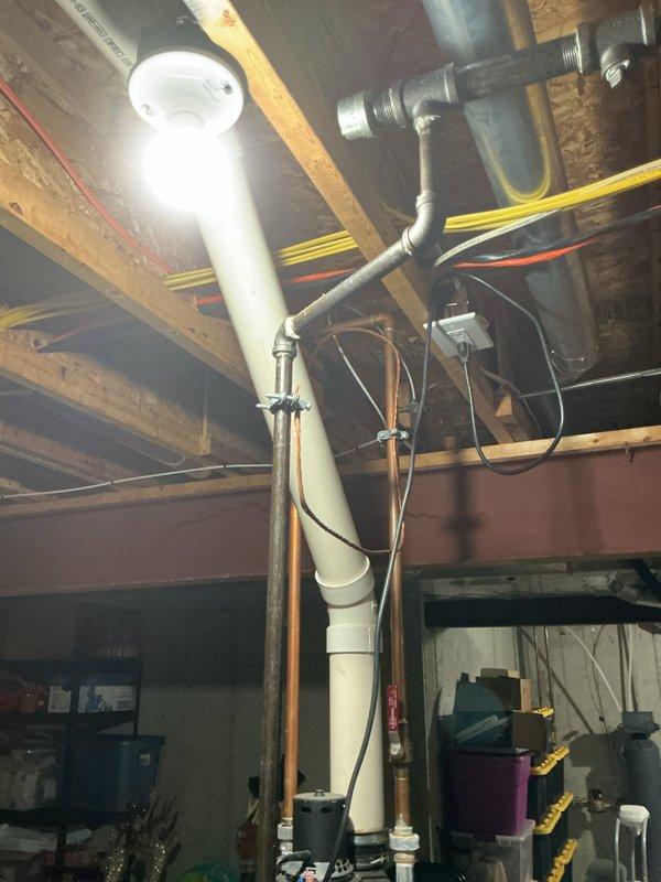 Conducted on-site assessment for water heater replacement in basement utility area. Evaluated existing tank-style water heater installation, plumbing connections, gas lines, venting requirements, and available space for potential relocation approximately several feet from current position. Documented existing conditions including water softener system, exposed ceiling joists, concrete block walls, PVC drainage and vent piping, gas supply lines, and electrical infrastructure. Reviewed both traditional tank-style and tankless water heater options with homeowner to determine optimal solution based on household hot water demands, available utilities, and spatial constraints. Provided comprehensive estimate covering equipment specifications, installation requirements, and necessary modifications to accommodate potential unit relocation.