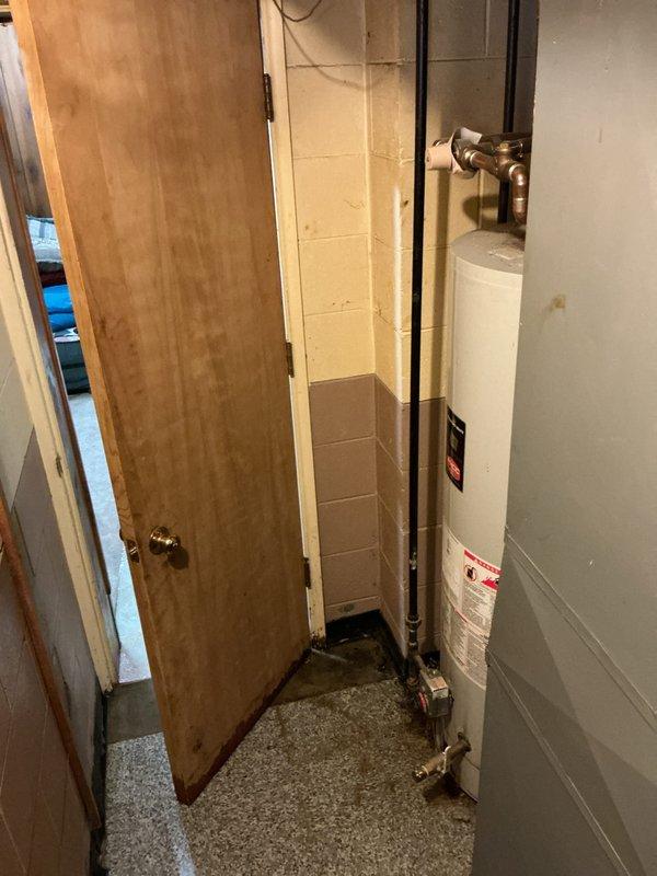 Responded to service call for leaking water heater in basement utility closet. Performed comprehensive inspection of existing residential water heater installation, documenting current condition with photographs. Unit exhibited active water leakage requiring replacement. Assessed plumbing configuration including copper supply lines, pressure relief valve assembly, and gas connections. Evaluated confined installation space with concrete block walls and limited access for equipment removal and replacement. Prepared detailed estimate for new water heater installation including necessary materials and labor.