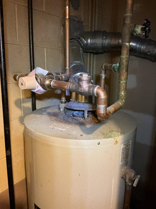 Responded to service call for leaking water heater in basement utility closet. Performed comprehensive inspection of existing residential water heater installation, documenting current condition with photographs. Unit exhibited active water leakage requiring replacement. Assessed plumbing configuration including copper supply lines, pressure relief valve assembly, and gas connections. Evaluated confined installation space with concrete block walls and limited access for equipment removal and replacement. Prepared detailed estimate for new water heater installation including necessary materials and labor.