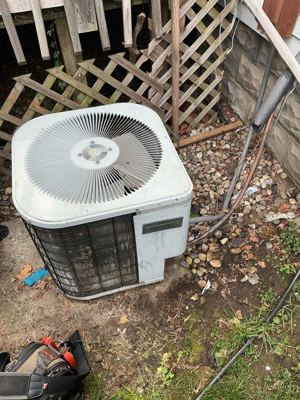 Responded to no-cooling call on 10-year-old residential AC system. Upon arrival, performed visual inspection of outdoor condensing unit and refrigerant line set. Unit showed signs of age and weathering with visible discoloration on exterior casing. Inspected condenser coil through protective grille and noted general condition of equipment. Examined refrigerant lines running from condenser to building, verifying insulation integrity and proper mounting. Checked electrical connections at outdoor disconnect and condensing unit. Documented equipment condition and installation setup with photos for service records. Unit location showed minimal maintenance over time with debris accumulation around base. Refrigerant lines properly insulated and secured to exterior wall with appropriate brackets. Verified contact information for follow-up communication regarding system diagnosis and repair recommendations.
