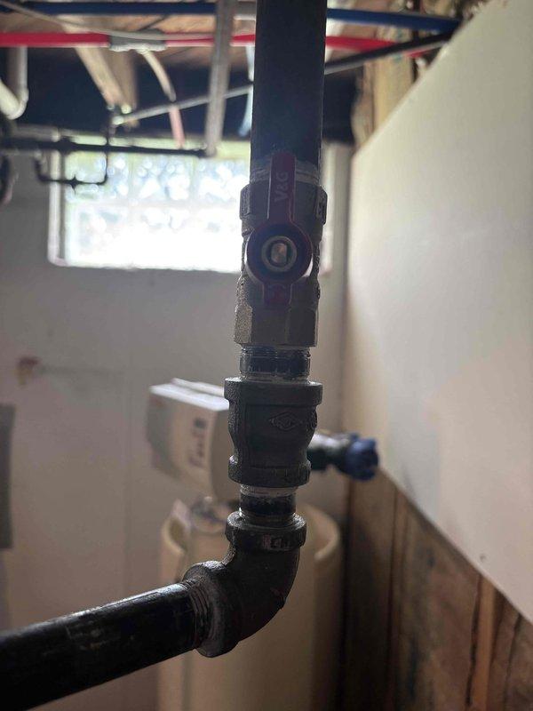 Returned to property to replace faulty gas shutoff valve on black iron pipe gas line. Removed existing valve assembly and installed new brass ball valve with red handle, ensuring proper threading and secure connections to vertical and horizontal pipe sections. Tested valve operation and verified proper shutoff function with no gas leaks detected.