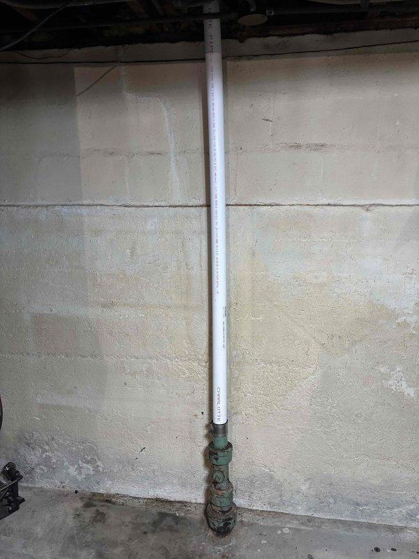 Completed comprehensive plumbing repairs in residential bathroom and basement utility area. Serviced bathroom sink faucet assembly with brushed nickel finish and dual lever handles, ensuring proper operation and addressing water flow issues. Inspected and cleared drain stopper mechanism in porcelain basin. In basement area, addressed corroded valve assembly at base of vertical PVC drainage line along foundation wall. Replaced heavily oxidized green valve fitting showing moisture damage and age-related deterioration. Verified proper drainage function and checked for leaks throughout system after repairs were completed.