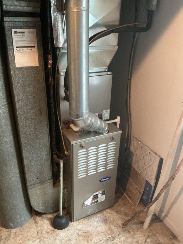 Responded to customer complaint regarding excessive indoor humidity causing mold growth with 14-year-old Carrier HVAC system. Performed diagnostic inspection of furnace and air conditioning equipment in basement mechanical room. Documented existing equipment configuration including Carrier furnace unit, ductwork system, and associated plumbing connections to assess potential causes of humidity control issues such as improper drainage, inadequate dehumidification capacity, or system cycling problems.