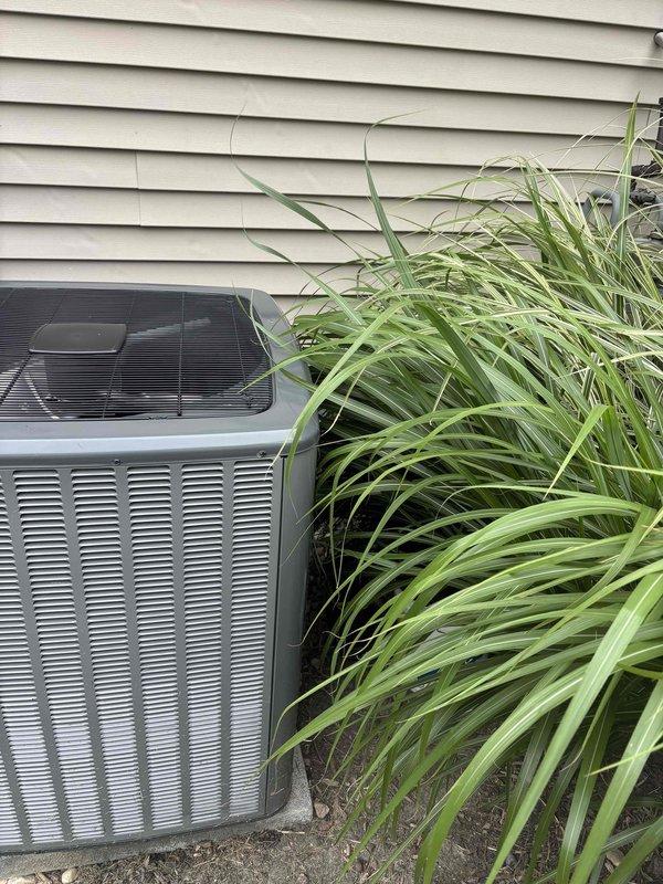 Responded to no cooling call on 2-year-old EnergiAir system. Upon arrival, performed diagnostic inspection of outdoor condenser unit and indoor air handler/furnace assembly. Documented equipment condition and surrounding installation environment, noting overgrown ornamental grass partially obstructing outdoor unit airflow. Captured photographic documentation of both outdoor condenser unit and indoor HVAC components for service records. System evaluated and findings communicated to customer with recommended next steps for restoration of cooling operation.