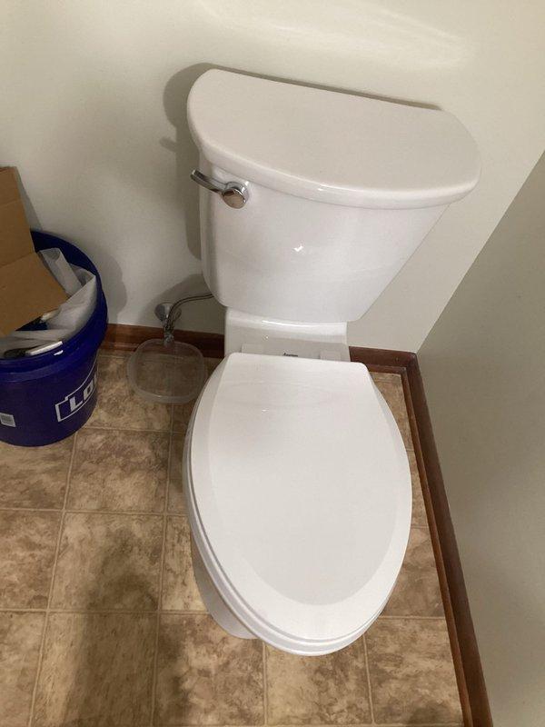 Completed installation of new residential toilet and faucet fixture in bathroom. Toilet was properly set on existing beige tile flooring with new wax ring seal, secured to flange, and connected to water supply line with shutoff valve. All connections were tested for proper operation and leaks, with successful completion verified.