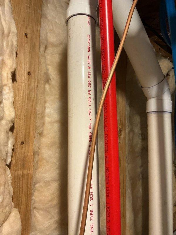 Responded to water heater leak with standing water present in drain pan. Upon inspection, confirmed active leakage from bottom of 3-year-old Bradford White unit. Documented gas valve assembly showing significant corrosion and water damage staining around control components, as well as plumbing configuration including PVC, copper, and PEX supply lines. Assessed unit condition and provided recommendations for repair or replacement based on extent of leak damage and age of equipment.