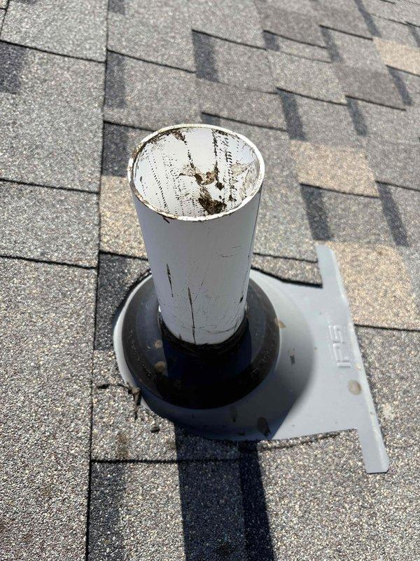 Responded to complaint of sewer-like odor in residence suspected to originate from clogged plumbing vent. Conducted comprehensive inspection of drainage system including under-sink plumbing configuration and rooftop vent stack. Examined kitchen sink drain assembly and PVC waste lines beneath cabinet for proper venting and trap function. Inspected rooftop plumbing vent stack and identified weathered paint condition on vent pipe with deteriorated rubber boot flashing at roof penetration. Documented existing plumbing conditions with photographs for service records. Assessed vent stack for potential blockages or restrictions that could cause negative air pressure and allow sewer gases to enter living space through fixture traps.