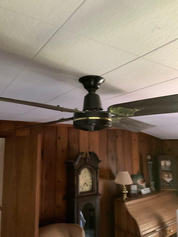 Conducted on-site assessment for ceiling fan installation in interior room with drop ceiling and wood paneling. Evaluated existing electrical outlets requiring replacement and documented current ceiling fan configuration. Provided quote for installation services and outlet replacement work.