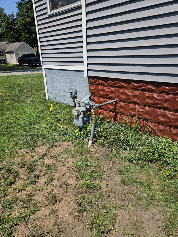 Completed installation of unit heater system at residential property. Installed exterior gas supply line with shutoff valve and meter connections on building exterior near foundation. Routed gas piping along side access pathway between structures. All components properly mounted to white siding with appropriate support brackets and sealed penetrations. System tested for proper operation and gas leaks, with all connections verified secure and functional.