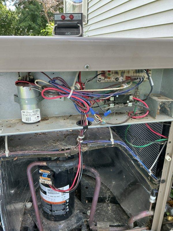 # CP-Cooling Problem Resolution

Responded to service call for 10-year-old York air conditioning system with no cold air coming from interior vents. Upon arrival, performed visual inspection of outdoor condensing unit. Found unit surrounded by excessive vegetation growth, with plants and vines growing against and through ventilation grille openings, significantly restricting airflow to condenser coil.

Removed access panel to inspect internal components. Observed accumulated dirt, debris, and organic matter on internal surfaces and components. Checked electrical connections at capacitor and compressor. Inspected refrigerant lines and condenser coil condition. Coil appeared darkened with debris accumulation, further reducing heat transfer efficiency.

Cleared vegetation from around unit perimeter to restore proper airflow clearance. Cleaned condenser coil and removed debris from internal compartment. Verified all electrical connections were secure. Cycled system to confirm proper operat