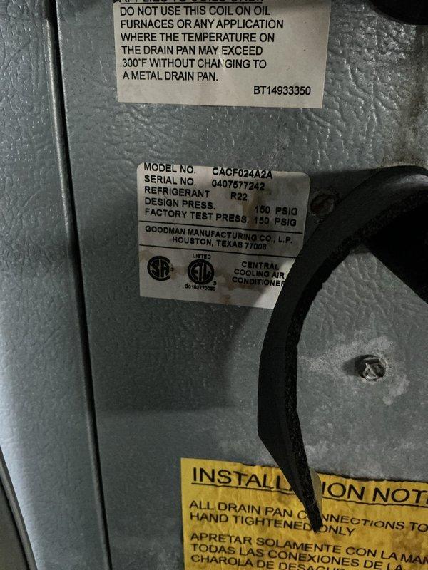 Completed annual cooling maintenance on a 21-year-old Goodman CACF024242 central air conditioning system utilizing R-22 refrigerant. Performed comprehensive tune-up inspection including evaluation of evaporator coil assembly, drain pan connections, and exterior condensing unit with electrical disconnect. Documented equipment condition with photographs showing manufacturer specifications and outdoor component installation on concrete pad with visible weathering to disconnect enclosure.