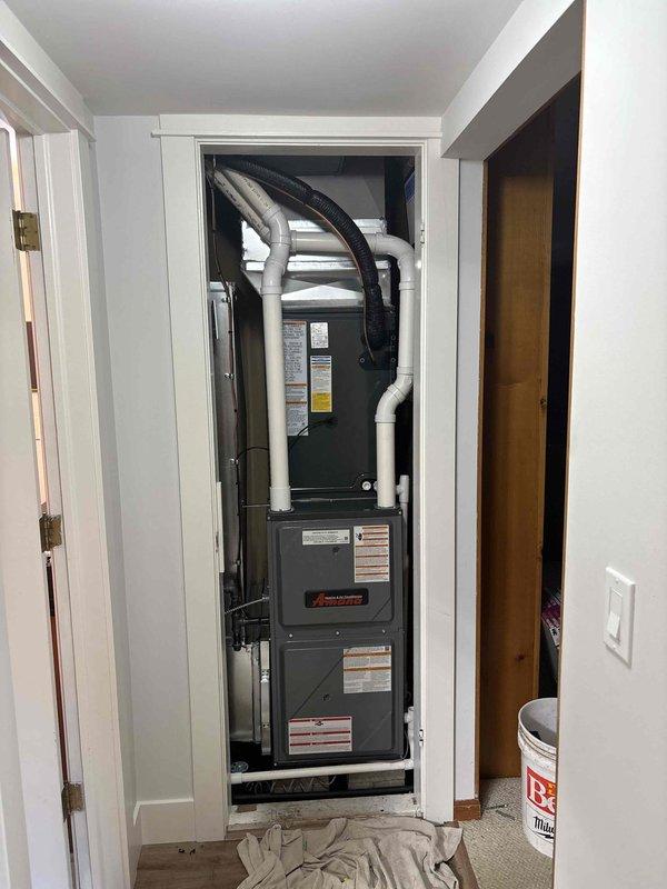 Completed full HVAC system installation including new furnace and air conditioning condenser unit. Installed vertically-oriented forced-air furnace in interior closet space with proper PVC condensate drainage and combustion air piping configuration. Mounted outdoor condenser unit on concrete pad with appropriate refrigerant line connections and electrical disconnect box. Configured return air ducting and verified all manufacturer specifications and safety requirements. System tested and operational upon completion.