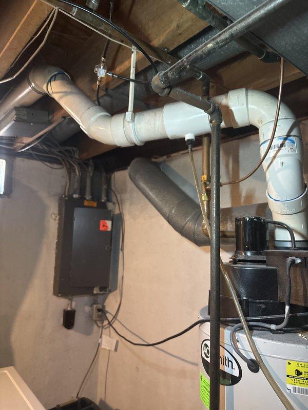 Responded to no hot water complaint on 14-year-old AO Smith water heater with visible corrosion on top connections. Upon inspection, confirmed extensive corrosion at inlet/outlet connections and determined unit had reached end of serviceable life. Documented existing installation configuration including copper supply lines, electrical connections, and proximity to HVAC ductwork and laundry appliances in basement utility area.