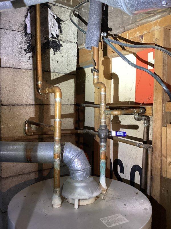 Provided estimate for replacement of 13-17 year old residential water heater exhibiting active leaking from bottom of tank. Upon inspection, documented existing standard cylindrical water heater installation in basement utility room with copper supply and distribution piping, proper venting, and electrical connections. Unit showed signs of age-related deterioration with bottom tank failure requiring full replacement rather than repair.