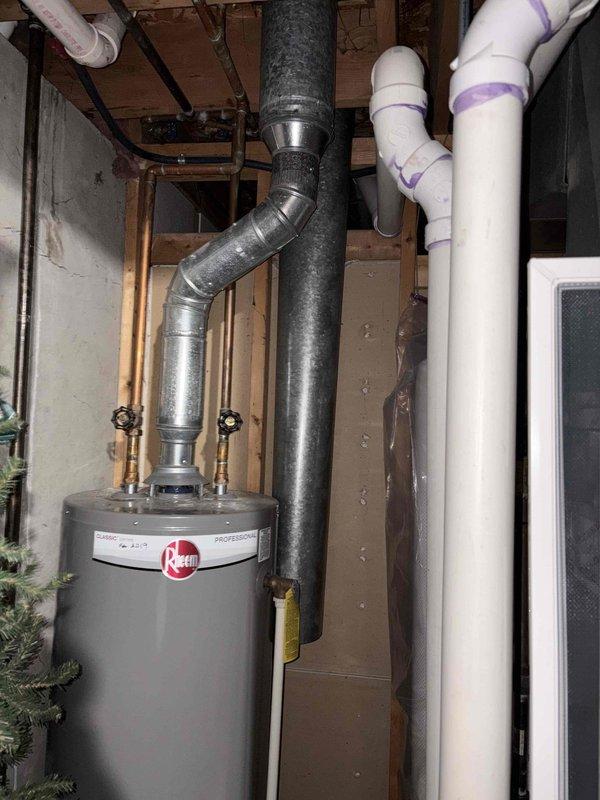 Replaced deteriorated water heater and furnace venting pipe system due to rust and corrosion concerns. Removed existing weathered metal vent pipe showing significant discoloration and water staining, then installed new stainless steel venting assembly with proper rain cap to coordinate with recently updated exterior siding.