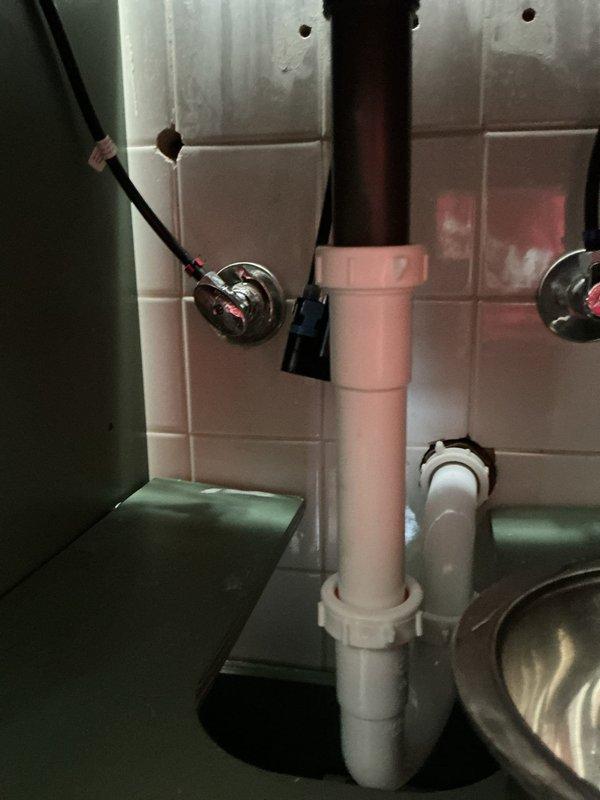 Responded to a plumbing leak at a bathroom sink hot water supply line. Upon inspection, identified the source of the leak in the supply connection beneath the vanity. Tightened the compression fitting on the hot water supply line to the faucet, eliminating the leak. Verified proper operation of the brass faucet assembly and confirmed no additional moisture or dripping from supply lines or P-trap assembly. System tested and restored to normal operation.