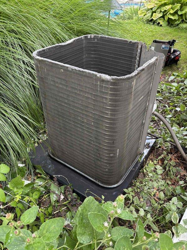 Completed annual cooling maintenance on a 6-year-old Lennox air conditioning system. Upon arrival, found outdoor condenser unit heavily soiled with thick accumulation of dirt, dust, and debris coating exterior panels and surrounding vegetation significantly overgrown around equipment. Performed comprehensive tune-up including thorough cleaning of condenser coils which showed dark buildup on horizontal fins, cleared debris from unit exterior and base, and trimmed back encroaching grass and plants to restore proper airflow clearance around unit. Inspected electrical components, refrigerant lines, and control board for proper operation. Verified system operational performance following cleaning and maintenance procedures. Unit restored to optimal operating condition with improved airflow and heat transfer efficiency.