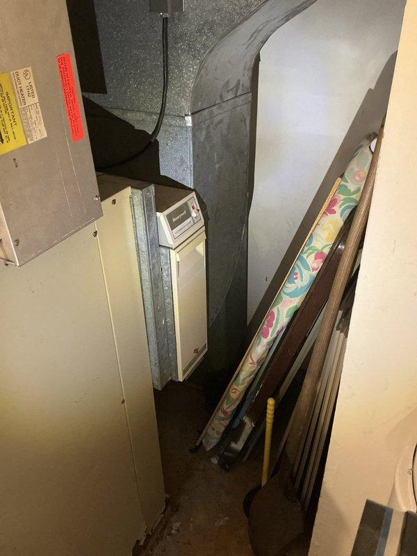 Completed geothermal estimate for replacement of indoor air handler unit on existing open loop geothermal heating and cooling system. Inspected 25-year-old furnace/air handler located in basement utility space with adjacent ductwork and control panel. Photographed existing equipment configuration including metal HVAC unit, cylindrical plenum ductwork, and interior duct components to document current installation for replacement specifications. Provided estimate for new indoor geothermal unit installation to replace aging equipment while maintaining existing ground loop system.