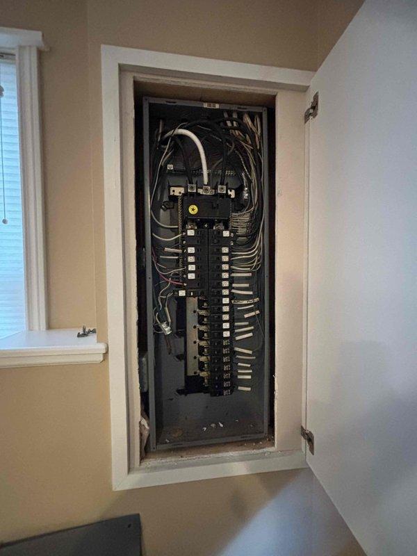 Evaluated electrical panel installation and existing wiring configuration to provide estimate for relocating an extension cord currently running underneath porch area. Documented current electrical panel conditions in both utility room and main living space, noting circuit breaker arrangements, wire routing, and connection points to determine proper method for safely relocating power source and eliminating exposed cord hazard beneath porch structure.