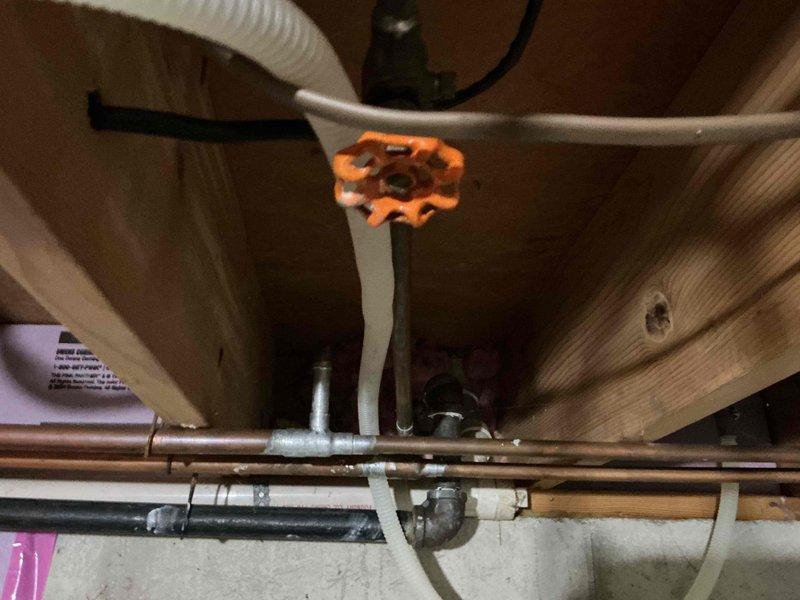 Responded to customer report of bathtub fixture failing to shut off completely and dripping garage spigots in 1975-built home. Inspected dual-valve exterior spigot fixture mounted on garage exterior and accessed plumbing system beneath floor joists to evaluate shut-off valves and supply lines. Repaired or replaced worn valve components to restore proper water shut-off function at bathtub fixture and eliminate dripping at garage spigots, returning both fixtures to normal operation.