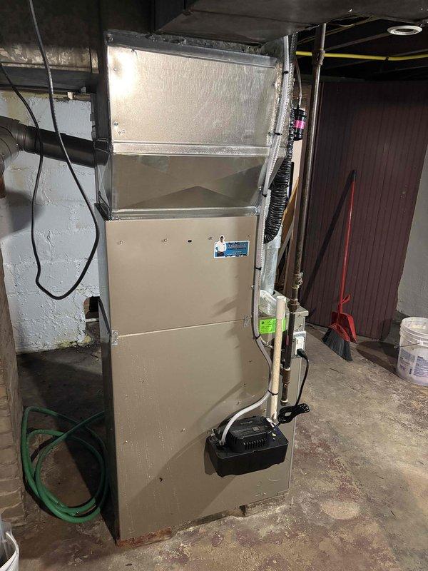 Completed full air conditioning system replacement at residential property. Installed new outdoor condensing unit on concrete pad with proper refrigerant line connections and electrical conduit routing to interior furnace system. Connected new AC coil to existing furnace unit in basement mechanical room, installed condensate pump for proper drainage, and verified all ductwork connections to air handler plenum. System startup performed with successful operational testing of all components.
