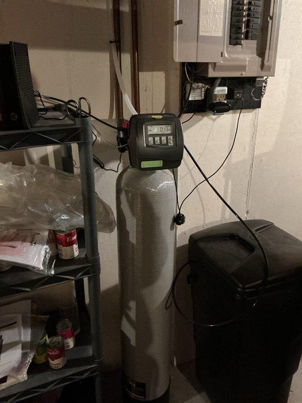 Responded to service call for Sterling water softener displaying error code 102. Upon arrival, found unit installed in January was showing fault code on digital control head. Diagnosed error code 102 as communication failure between control valve and system components. Reset control head by power cycling unit at electrical panel, cleared error code from system memory, and verified proper voltage supply to control unit. Reprogrammed controller settings and confirmed system returned to normal operation with display functioning correctly. Tested water flow through softener tank and verified regeneration cycle initiation. Inspected plumbing connections for proper installation and checked for any signs of leaks or mechanical issues—all connections secure with no moisture present. Examined household faucets as requested and found no issues with fixtures. Educated customer on proper operation of control head and how to monitor system status. Unit now operating as designed with error code reso
