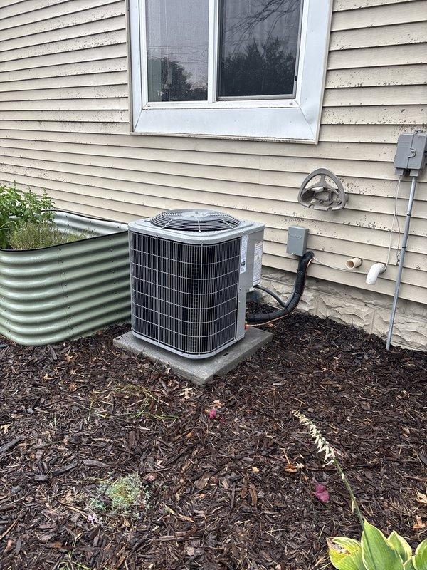 Completed full residential air conditioning system replacement including outdoor condenser unit and indoor air handler. Outdoor condenser unit installed on existing concrete pad with proper electrical connections and conduit routing along exterior siding. Indoor air handler positioned in utility room alongside existing furnace with appropriate clearances maintained. All refrigerant lines connected, PVC condensate drainage installed, and ductwork integrated with existing HVAC system. System tested, charged to manufacturer specifications, and verified operational.