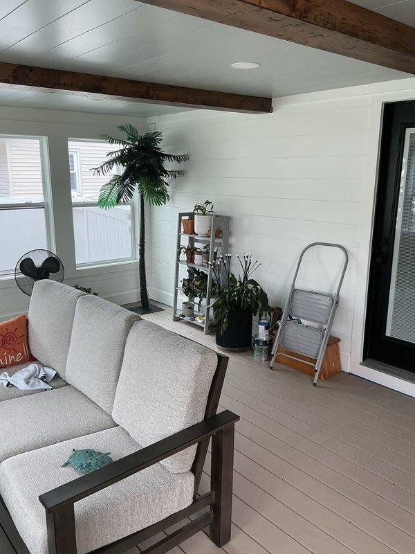 Conducted estimate for mini split installation in four seasons room with white shiplap walls and vaulted ceiling featuring exposed wooden beams. Assessed interior space layout, electrical access points on exterior gray siding, and determined optimal equipment placement for climate control system. Documented existing conditions and provided recommendations for ductless heating and cooling solution.